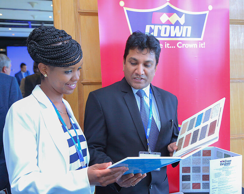 Crown Paints, Head of Sales, Rakesh Ranjan (right) and Kenya Private Developers Association- CEO, Elizabeth Mwangi Oluoch go through different colour samples of paints available at Crown Paints.