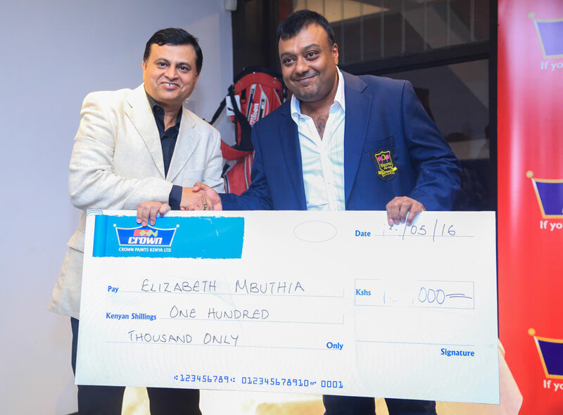 Crown Paints CEO Rakesh Rao presents a cheque to Elizabeth Mbuthia who won a home makeover worth Ksh 100,000 at Sigona Golf . The Club chairman Kamal Shah received the cheque on her behalf